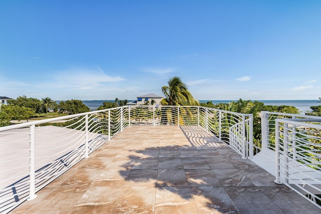 view of patio / terrace featuring a water view and a balcony