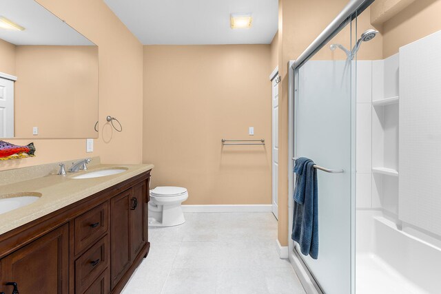 bathroom featuring vanity, toilet, a shower with shower door, and tile patterned flooring