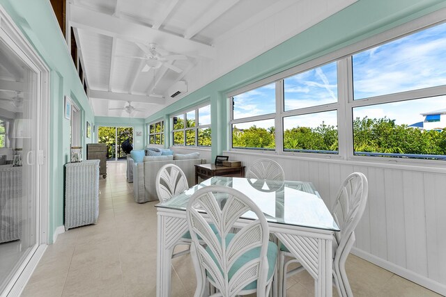 sunroom / solarium with ceiling fan, vaulted ceiling with beams, and a wall unit AC