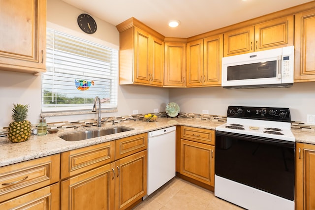 kitchen with light stone counters, white appliances, sink, and light tile patterned floors