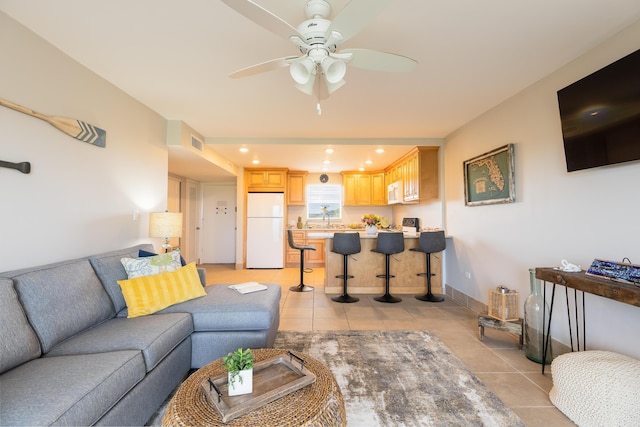 living room featuring light tile patterned flooring, ceiling fan, and sink