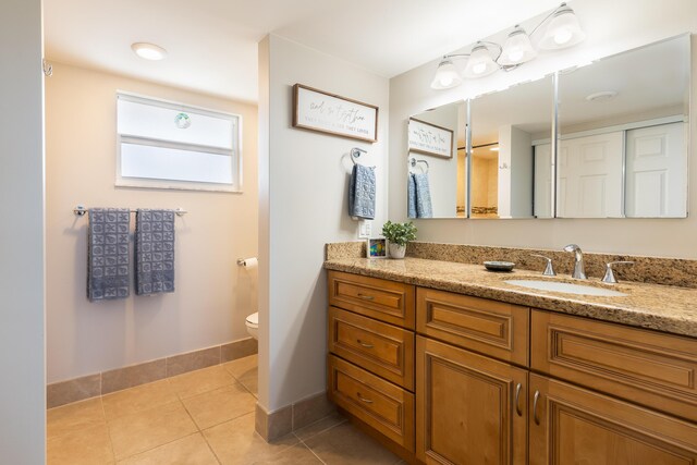 bathroom with vanity, tile patterned floors, and toilet