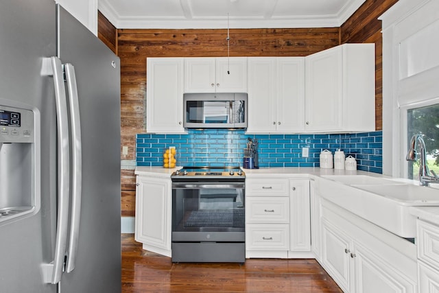 1203 Newton St Unit 2, Key West, FL 33040 - kitchen featuring stainless steel appliances, wood walls, light countertops, decorative backsplash, and a sink