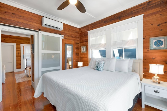 1203 Newton St Unit 2, Key West, FL 33040 - bedroom featuring wood walls, a wall mounted air conditioner, wood finished floors, a ceiling fan, and a barn door