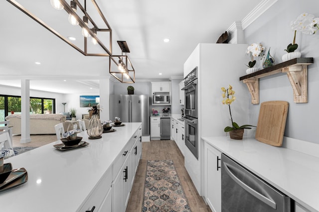 1610 Von Phister St, Key West, FL 33040 - kitchen featuring appliances with stainless steel finishes, white cabinets, light countertops, light wood-style floors, and recessed lighting