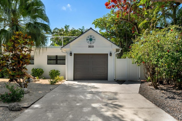 1610 Von Phister St, Key West, FL 33040 - view of front facade featuring concrete driveway, an attached garage, and stucco siding