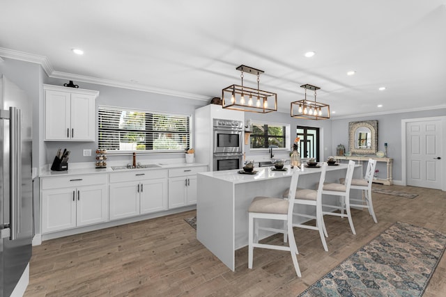 1610 Von Phister St, Key West, FL 33040 - kitchen featuring a sink, stainless steel double oven, ornamental molding, healthy amount of natural light, and white cabinetry