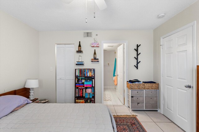 3635 Seaside Dr Unit 314, Key West, FL 33040 - bedroom with visible vents, a closet, light tile patterned floors, a ceiling fan, and a textured ceiling