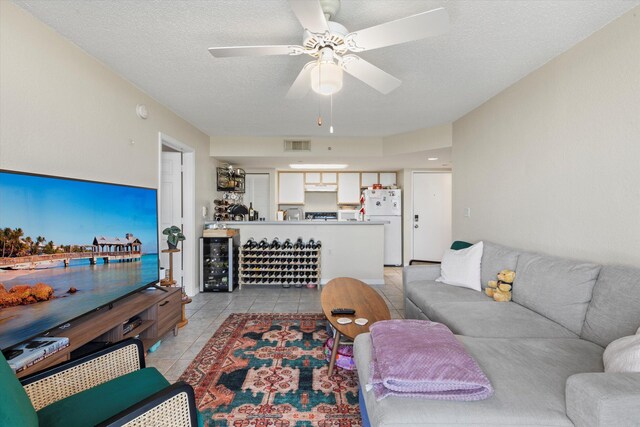 3635 Seaside Dr Unit 314, Key West, FL 33040 - living area with a textured ceiling, a ceiling fan, light tile patterned flooring, visible vents, and beverage cooler