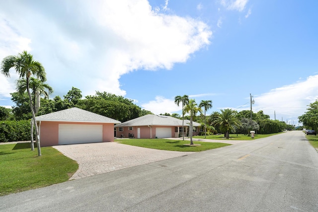 single story home featuring a garage and a front lawn