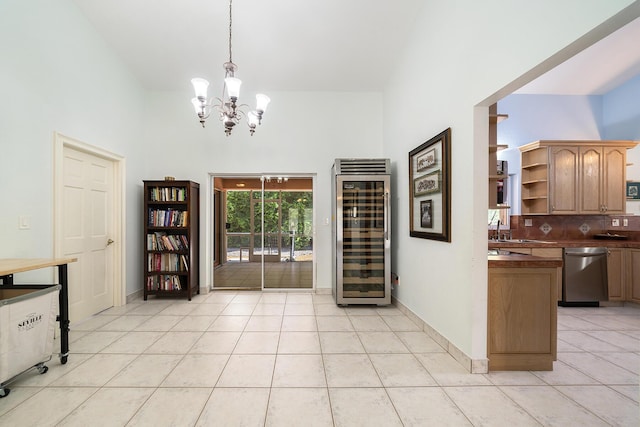 interior space featuring wine cooler, sink, an inviting chandelier, and light tile patterned floors