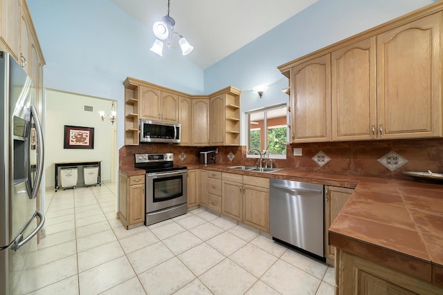 kitchen with light tile patterned flooring, sink, tasteful backsplash, a notable chandelier, and stainless steel appliances