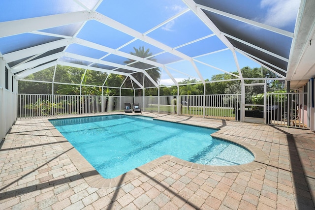 view of pool with a patio and glass enclosure