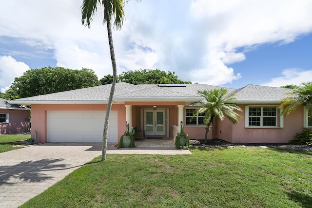 single story home featuring a garage, a front lawn, and french doors