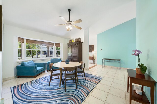 tiled dining room featuring ceiling fan and vaulted ceiling