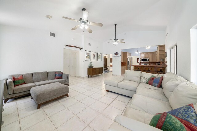 living room with light tile patterned flooring, ceiling fan, and high vaulted ceiling