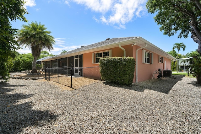 view of side of home with central AC and a sunroom