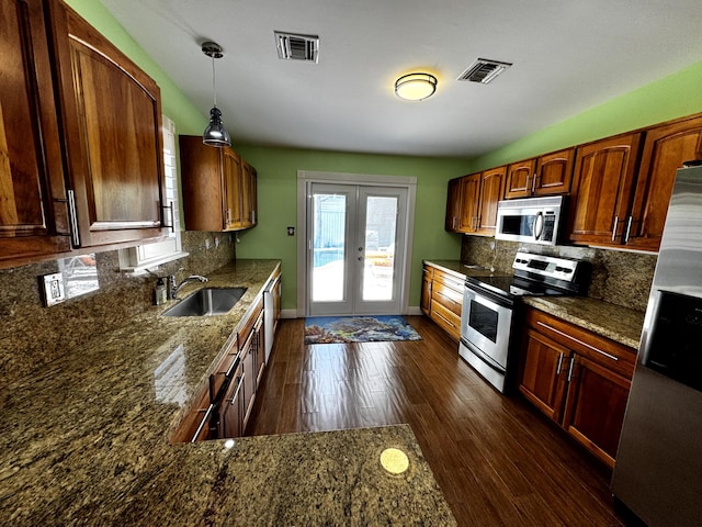 318 Margaret St, Key West, FL 33040 - kitchen featuring stainless steel appliances, a sink, french doors, dark wood finished floors, and decorative backsplash