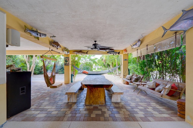 view of patio with exterior bar and ceiling fan