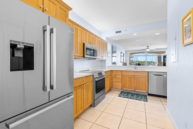 kitchen featuring ceiling fan, stainless steel appliances, sink, and light tile patterned floors