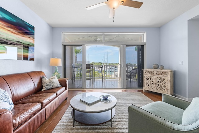 living room with wood-type flooring and ceiling fan