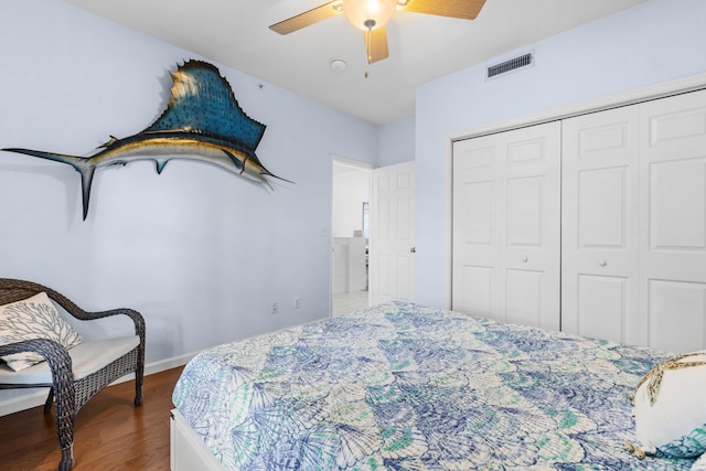 bedroom with dark wood-type flooring, ceiling fan, and a closet