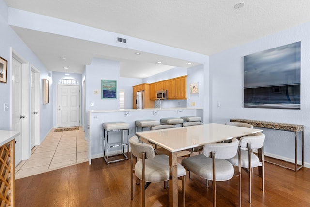 dining space with wood-type flooring