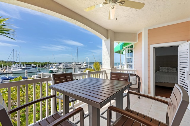 balcony with a water view and ceiling fan