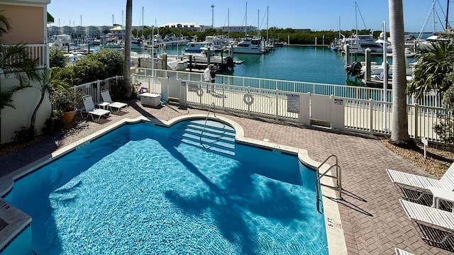 view of swimming pool with a water view and a patio area