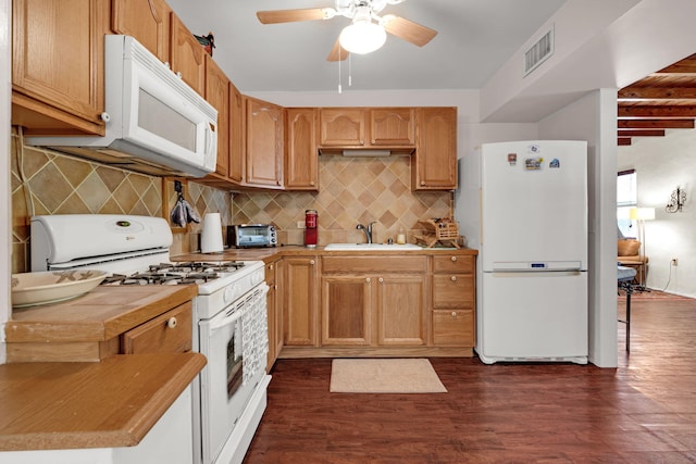 kitchen featuring visible vents, dark wood-type flooring, tile counters, white appliances, and a sink