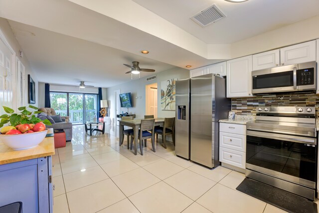 3314 Northside Dr Unit 31, Key West, FL 33040 - kitchen featuring appliances with stainless steel finishes, backsplash, white cabinetry, open floor plan, and light tile patterned floors