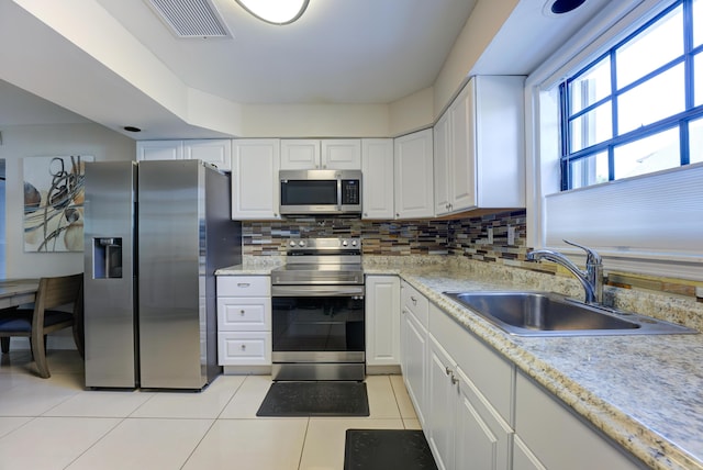 3314 Northside Dr Unit 31, Key West, FL 33040 - kitchen with appliances with stainless steel finishes, a sink, light tile patterned flooring, white cabinetry, and light countertops