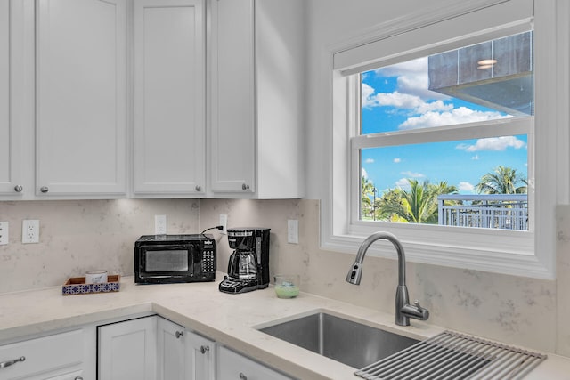 kitchen featuring light stone counters and white cabinets