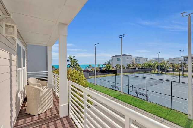 balcony with tennis court and a water view