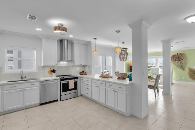 kitchen with wall chimney exhaust hood, stainless steel appliances, sink, and white cabinets