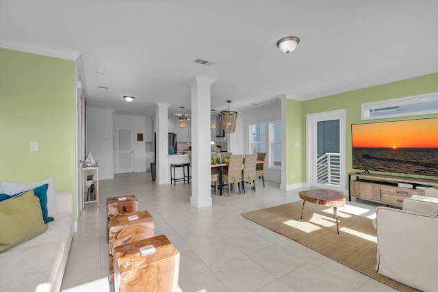 living room featuring light tile patterned floors, ornamental molding, and decorative columns