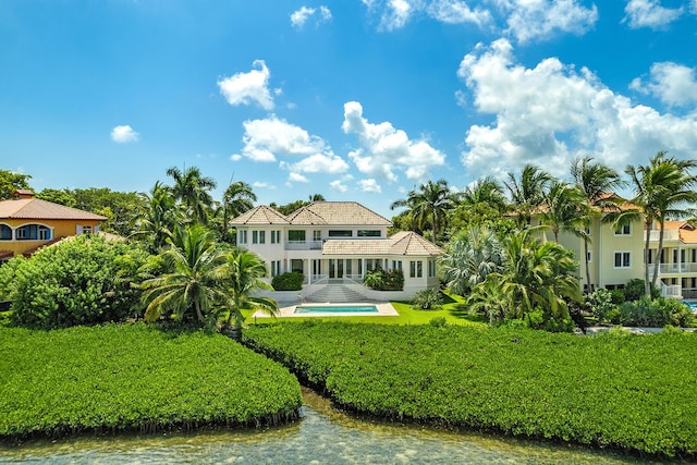 rear view of property with a patio, a balcony, and a water view