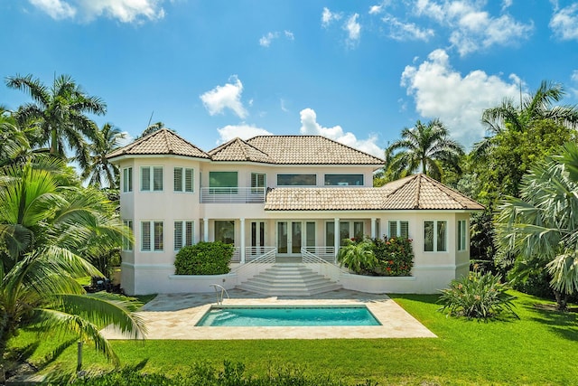 back of house with a balcony and a lawn