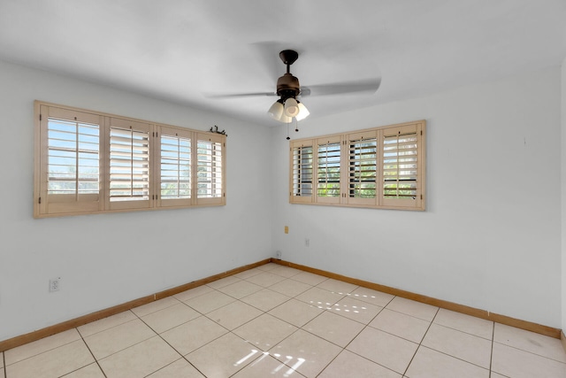 empty room featuring ceiling fan and baseboards