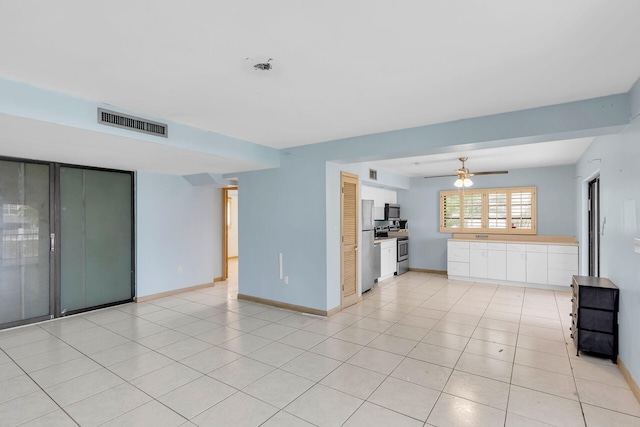 unfurnished living room with light tile patterned floors, ceiling fan, visible vents, and baseboards