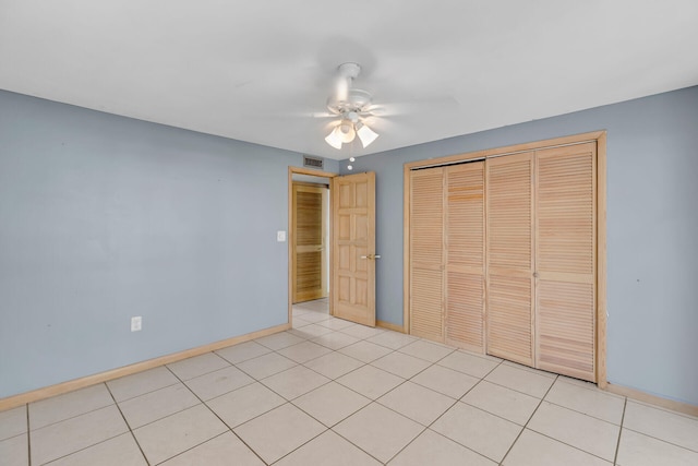 unfurnished bedroom featuring light tile patterned floors, a closet, visible vents, a ceiling fan, and baseboards