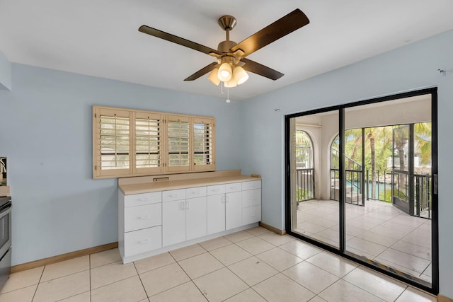 entryway with light tile patterned floors, ceiling fan, and baseboards