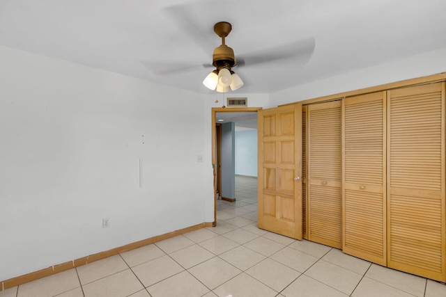 unfurnished bedroom with ceiling fan, light tile patterned flooring, visible vents, baseboards, and a closet