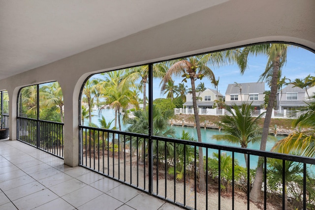 unfurnished sunroom with a residential view and a water view