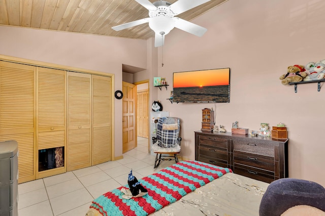 tiled bedroom featuring a ceiling fan, a closet, wooden ceiling, and vaulted ceiling