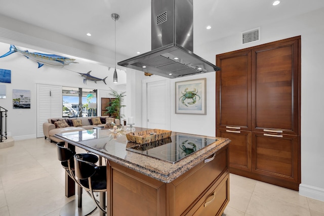 kitchen with stone countertops, a kitchen island, pendant lighting, island exhaust hood, and black electric stovetop