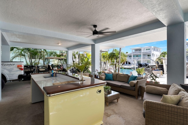 interior space with outdoor lounge area and ceiling fan