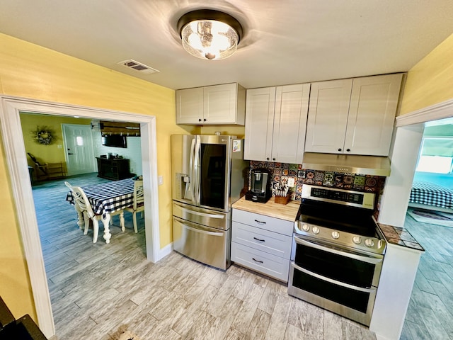 kitchen featuring stainless steel appliances, white cabinetry, and light hardwood / wood-style floors