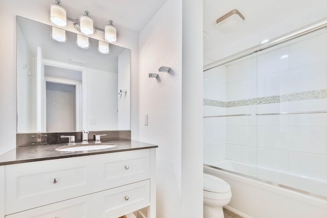 full bathroom with tiled shower / bath, vanity, and toilet