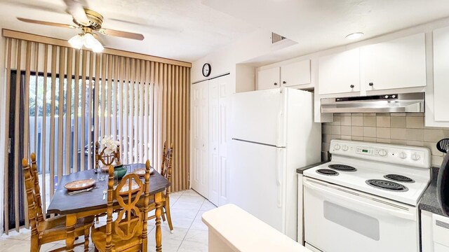 kitchen with light tile patterned floors, white appliances, ceiling fan, backsplash, and white cabinets